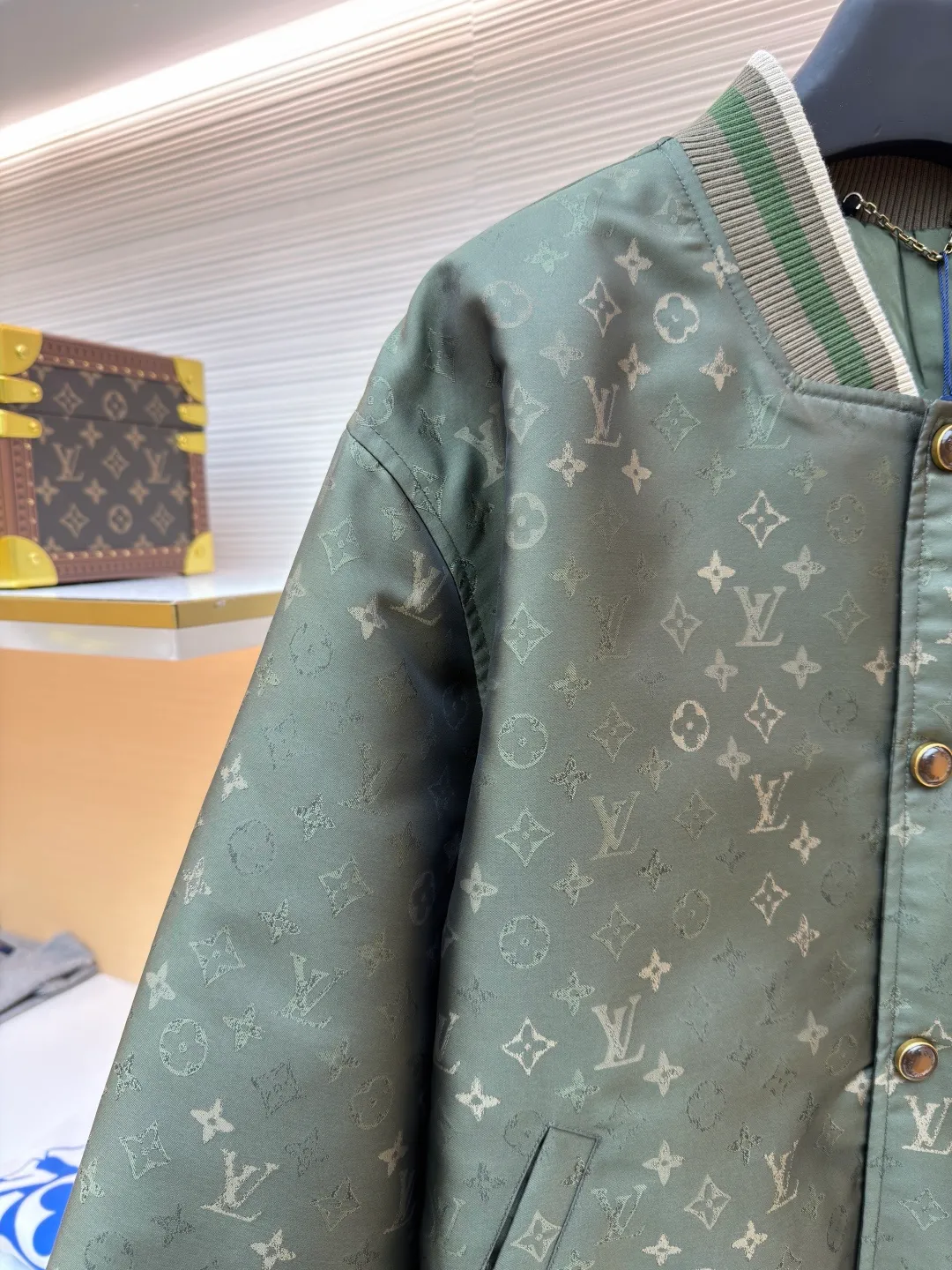 LOUIS VUITTON striped trim jacquard long-sleeved bomber jacket ●Original version: purchased and developed by 29237 ●Item number: 1682087-C05 ●Fabric: nylon fabric ●Technology: jacquard production ●Color: green ●Version: fitted version ●Weight: about 800 grams ●Size: S-M-L-XL ●Description: This Louis Vuitton baseball jacket is made of high-density jacquard satin fabric. The base is a polyester fiber blended material with a military green matte texture. The classic Monogram presbyopia pattern is woven into the fabric in the form of dark patterns of the same color through a special weaving process. The pattern texture is three-dimensional and presents a delicate illusion luster with the angle of light. High-precision jacquard weaving technology is used in the process to ensure the integrity and delicacy of the pattern. The body adopts a single-row metal snap closure design. The metal buckles are matte and distressed to echo the color of the body. The ribbed collar, cuffs and hem are made of two-color knitting technology. The elastic ribs have both stiffness and comfort, and are pre-shrunk to prevent deformation. The overall cut is a loose oversize version, and the splicing uses a combination of flat seams and hemming techniques. The interior is supplemented by smooth overlock sewing. Every stitch is even and fine, which fully reflects the brand's exquisite garment production technology and detail control. The overall wiring is straight and delicate, the fabric is comfortable and soft, and the color is consistent without color difference. It can be matched with the same style to create a fashionable look and control various occasions. Customized accessories, complete with three standards, same style for men and women!